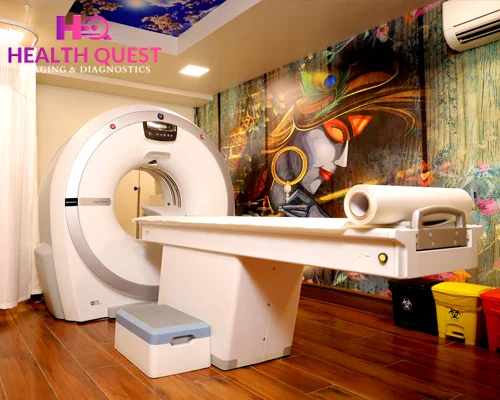 Why CT Scan in Gurugram Is Essential for Early Disease Detection Modern CT scan room at Health Quest Imaging & Diagnostics featuring a state-of-the-art CT scanner, patient table, wooden flooring, and artistic wall mural for a comfortable diagnostic environment.