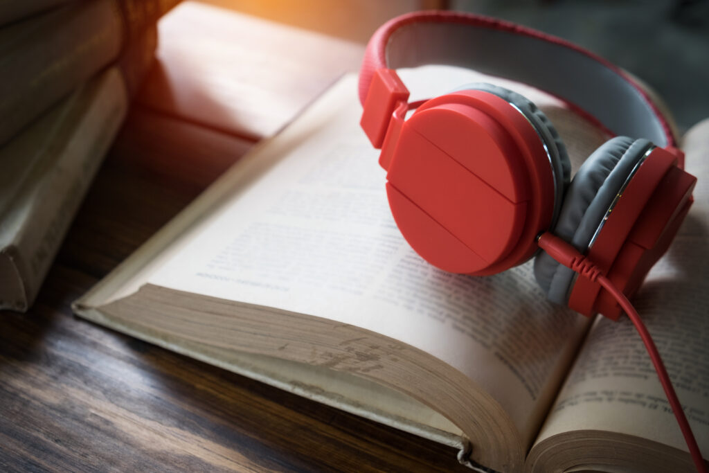 concept of audiobook. books on the table with headphones put on
